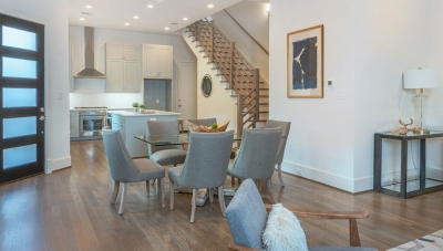 Living room open to kitchen with a staircase entering in the middle. 