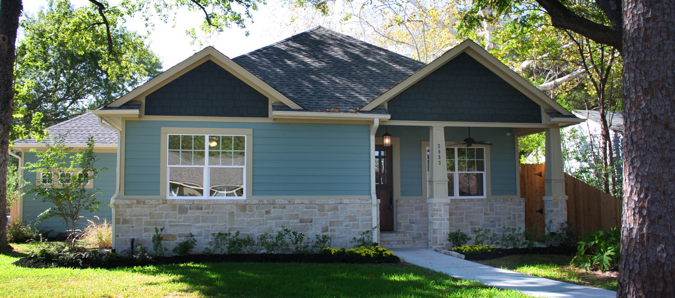 Ranch home with stone foundation and plank siding. 