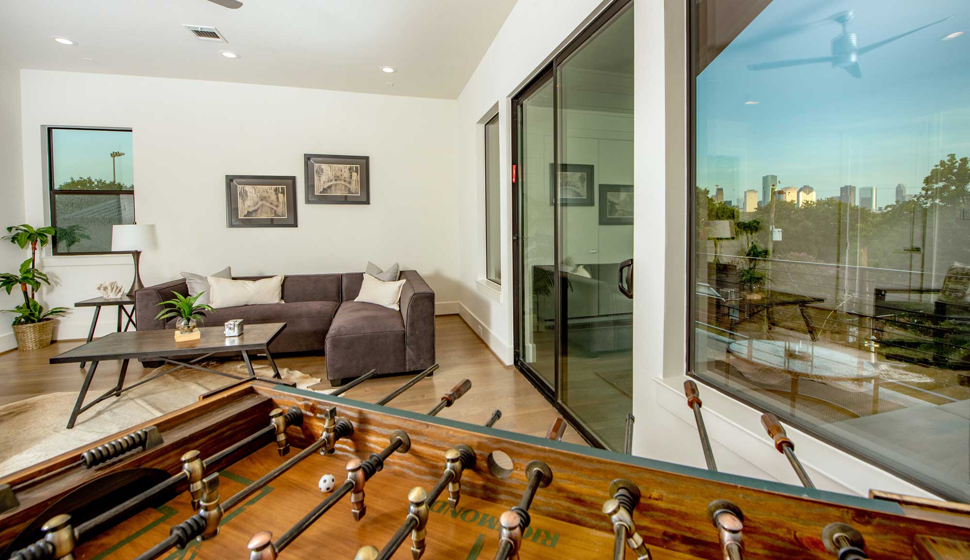 Oversized covered terrace with impressive views of downtown Houston reflected in the glass doors and windows.