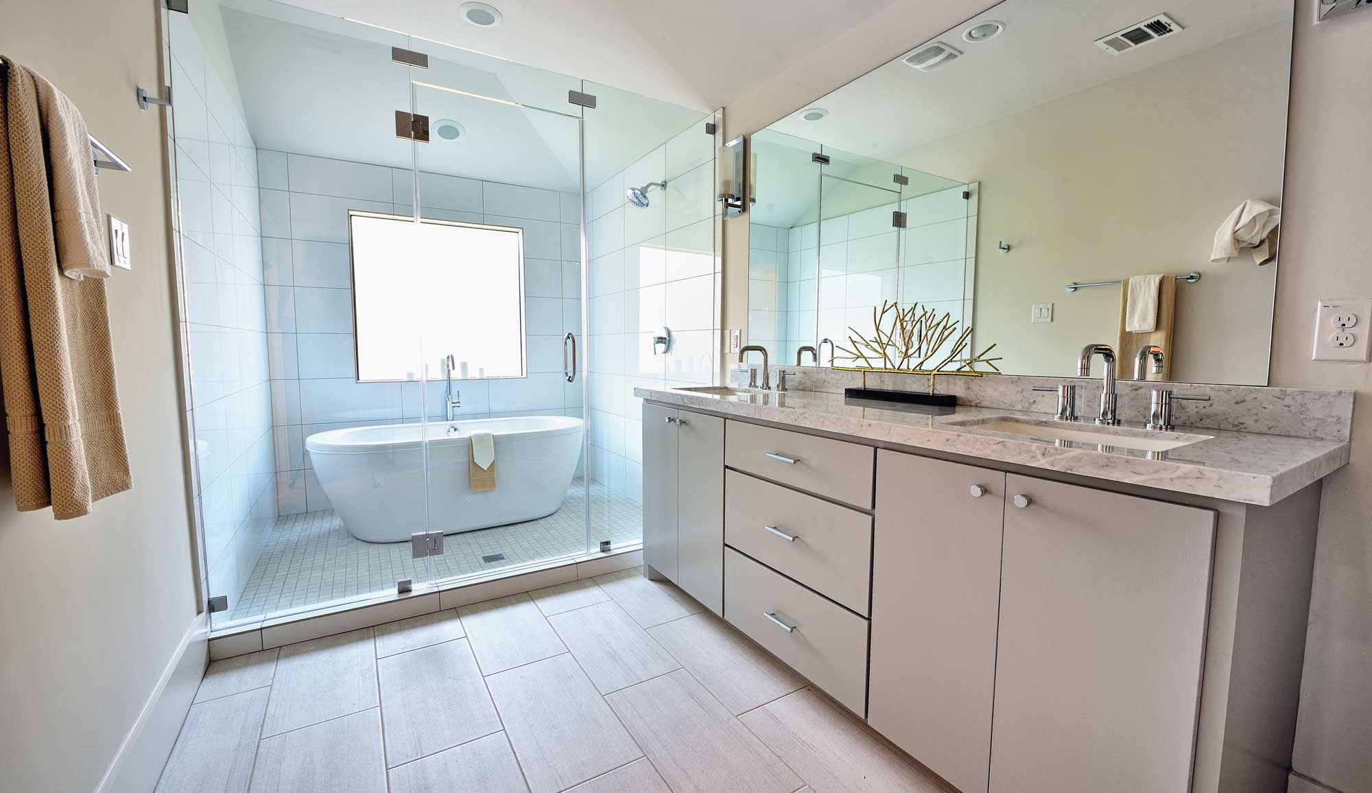 Bathroom featuring a deep water tub enclosed in the walk-in shower along with double sinks and tile flooring. 