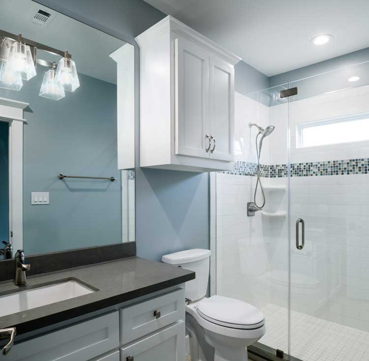 Bathroom with sink, toilet, and shower with glass door entry